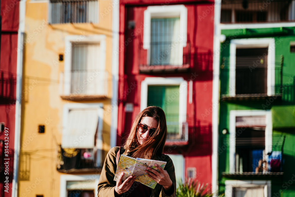 young woman holding a map outdoors at sunset. colorful city background. travel concept young woman holding a map outdoors at sunset. colorful city background. travel concept