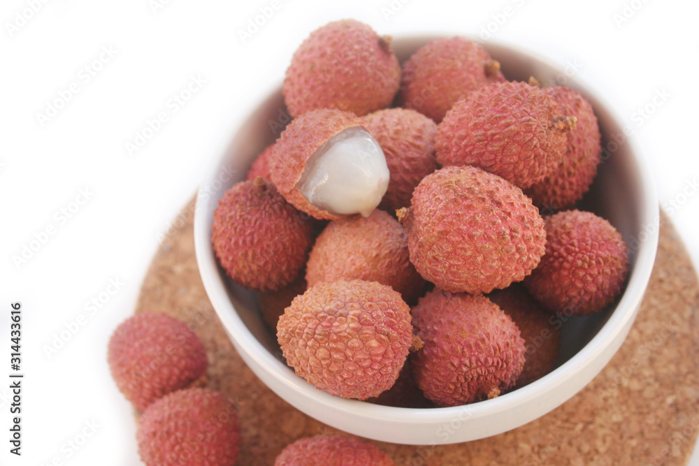Fresh ripe litchi or lychee fruits in a bowl isolated on white background. Litchi chinensis fruit Fresh ripe litchi or lychee fruits in a bowl isolated on white background. Litchi chinensis fruit