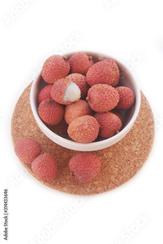 Fresh ripe litchi or lychee fruits in a bowl isolated on white background. Litchi chinensis fruit