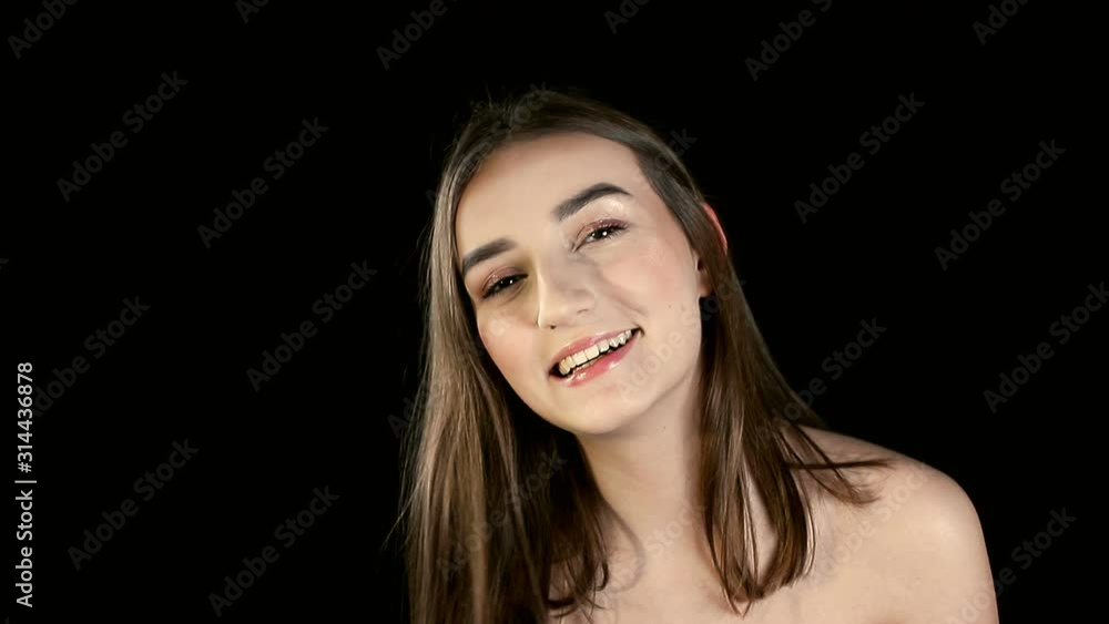 Fashion girl with black hair, brunette smiling and posing for the camera on a black background. Fashion girl with black hair, brunette smiling and posing for the camera on a black background.