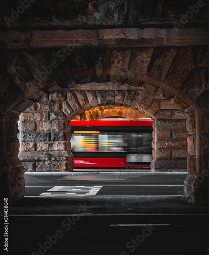 Photography Light rail carriage in motion behind sandstone arches