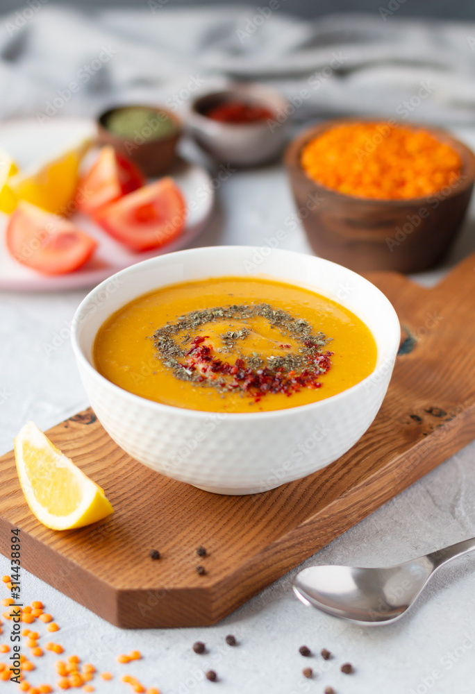 Thick red lentil soup served with lemon, dried mint and paprika. Turkish and Indian cuisine. Vertical orientation Thick red lentil soup served with lemon, dried mint and paprika. Turkish and Indian cuisine. Vertical orientation