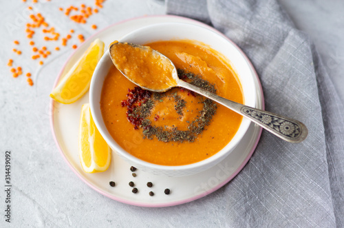 Thick red lentil soup served with lemon, dried mint and paprika. Turkish and Indian cuisine. Top view