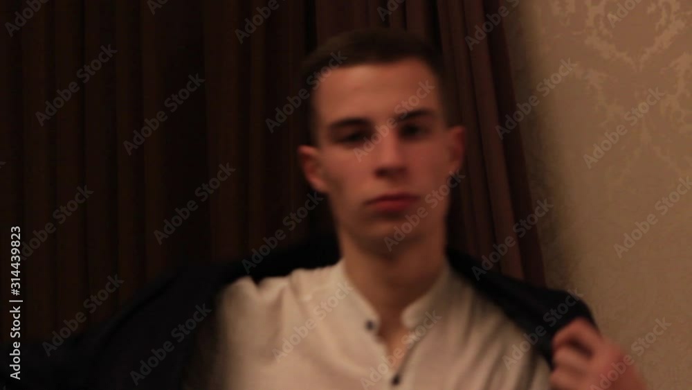 The guy puts on a jacket. The guy takes a jacket from a chair. Blazer. Business clothes. Costume. Hotel room. Business. Close-up. The guy puts on a jacket. The guy takes a jacket from a chair. Blazer. Business clothes. Costume. Hotel room. Business. Close-up.