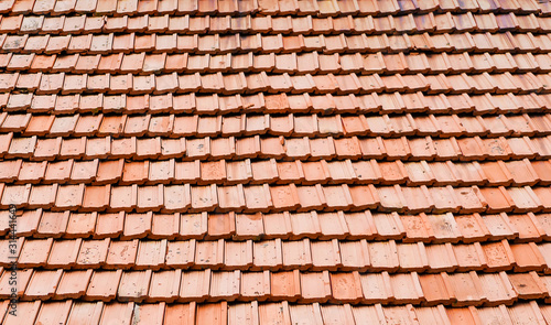 Texture of old red clay roof tiles on a building roof