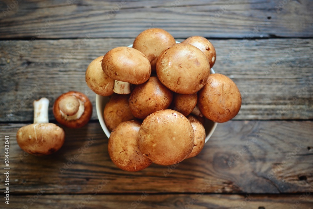 Royal fresh mushrooms on a wooden background. Whole brown mushrooms Royal fresh mushrooms on a wooden background. Whole brown mushrooms