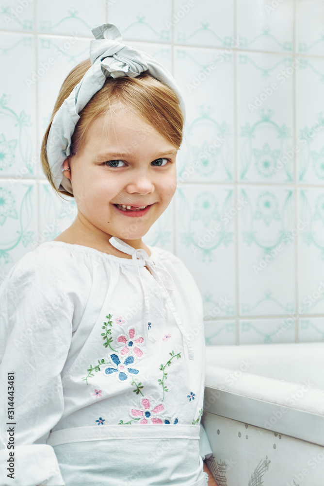 portrait of a little cute girl in the kitchen. child mistress with a  headscarf tied on her head Stock Photo | Adobe Stock