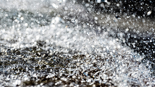 Water splash with small drops in the fountain. Abstract natural, selective focus background