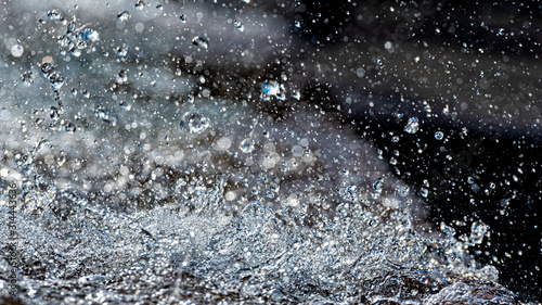 Water splash with small drops in the fountain. Abstract natural  selective focus  background