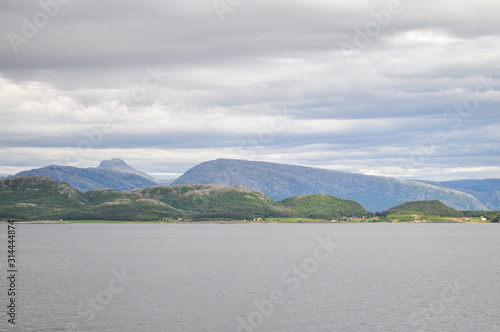 View to the cloudy sky over the sea and Vega archipelago mountains from a ferry deck in Nordland county, Norway on summer day