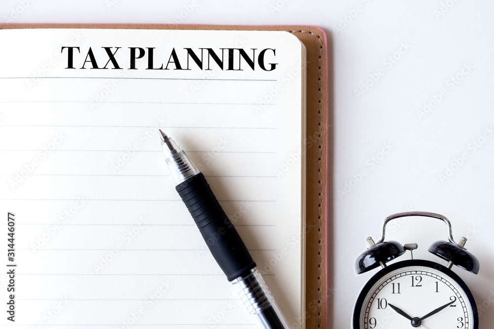 Conceptual,notebook on a white table. open diary and pen with tax planning words Conceptual,notebook on a white table. open diary and pen with tax planning words
