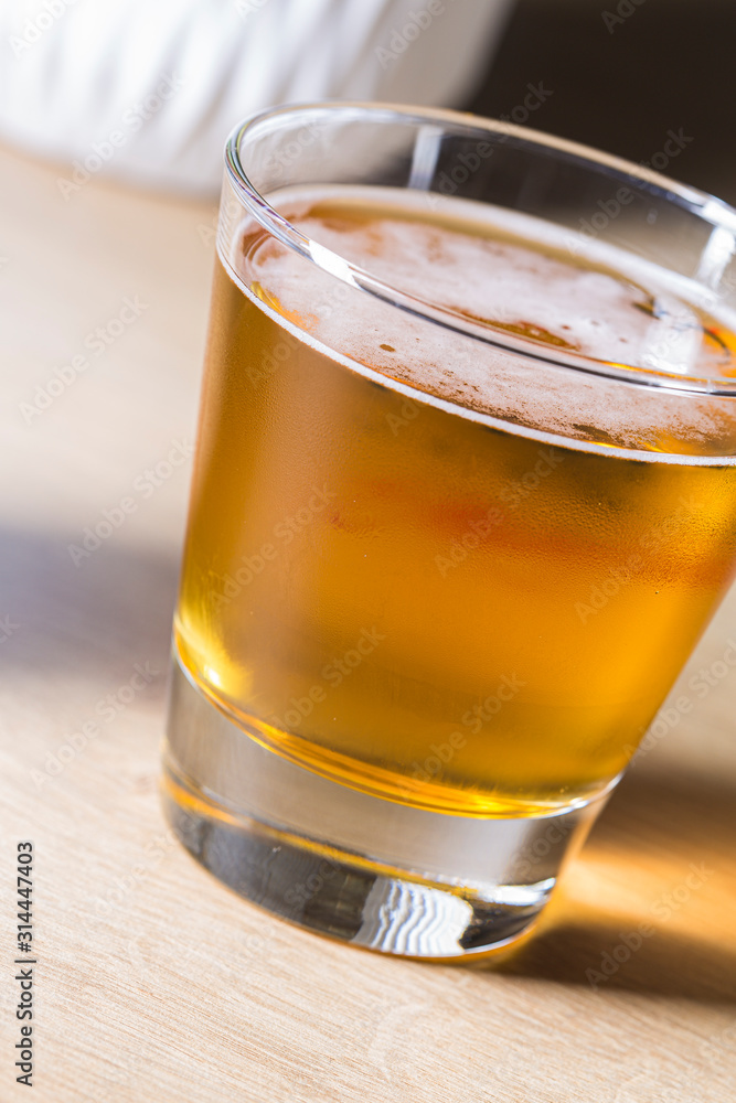 White froth on a blond beer served on a glass macro still White froth on a blond beer served on a glass macro still