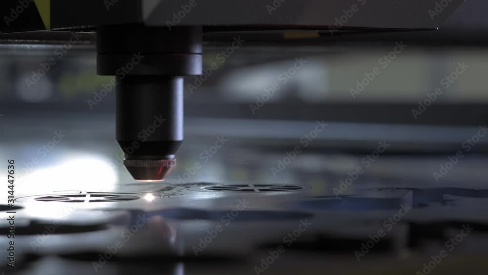 Industrial Laser cutting on wood, cutting a pattern on a plywood sheet and moving slowly, close up. A large technological machine burns through a wooden board. New technologies in woodworking. Industrial Laser cutting on wood, cutting a pattern on a plywood sheet and moving slowly, close up. A large technological machine burns through a wooden board. New technologies in woodworking.