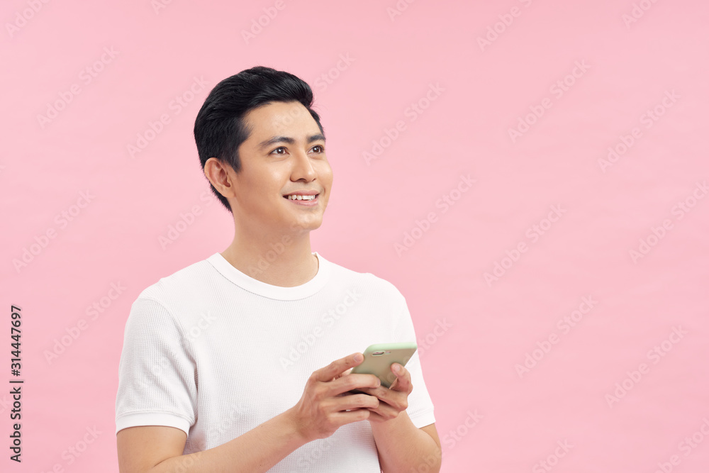 Asian man in white T-shirt is feeling happy with the smartphone.