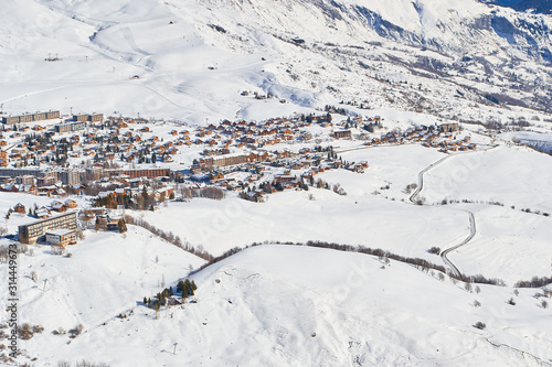 La Toussuire mountain village as seen from high up on the mountain, in Les Sybelles ski domain. Winter view on a sunny day.