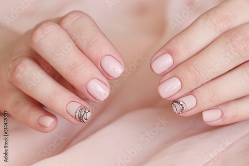 idea manicure creative light pink gel polish close-up with a pattern of black stripes and crystals