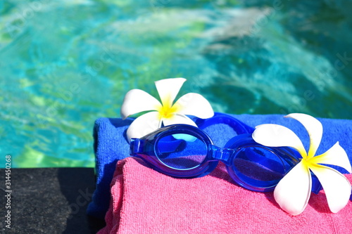 Swimming goggles on a towel by the pool. Luxury quiet holiday in the seaside resort. beautiful pool in the hotel. 