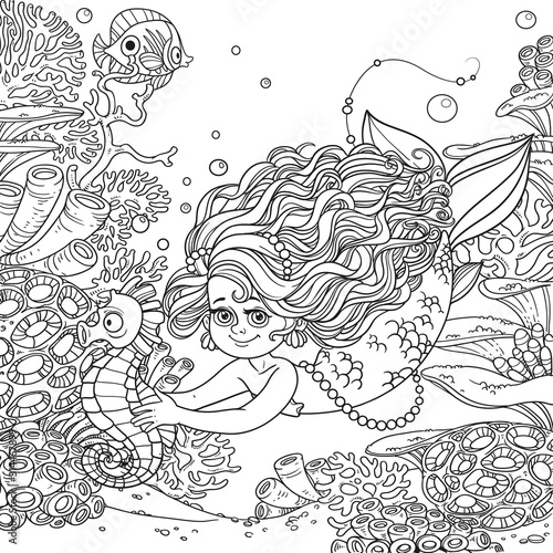Beautiful little mermaid girl swimming with sea horse in the hands on underwater world with corals, anemones and fish background