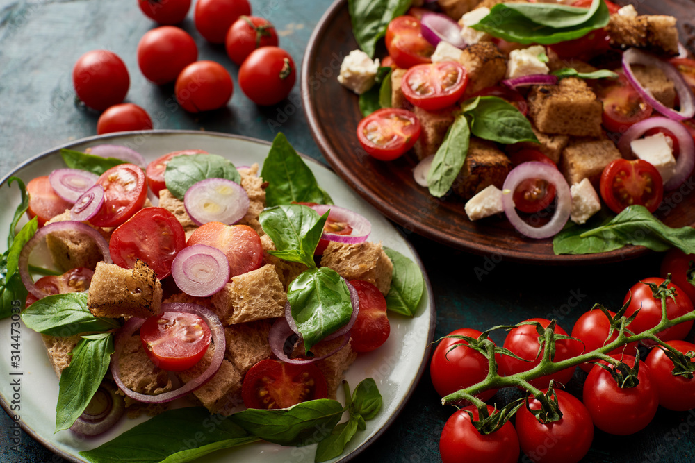 fresh Italian vegetable salad panzanella served on plates on table with tomatoes - obrazy, fototapety, plakaty 