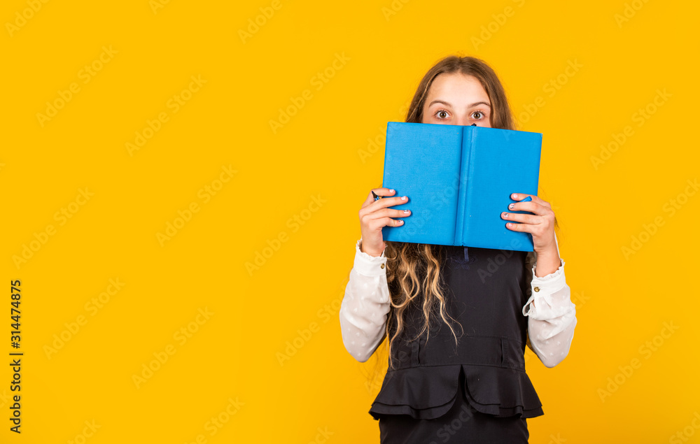 Hooked on book. Small child cover face with book. Little girl read book yellow background. Cute bookworm. Adorable bibliophile. School library. Book shop, copy space