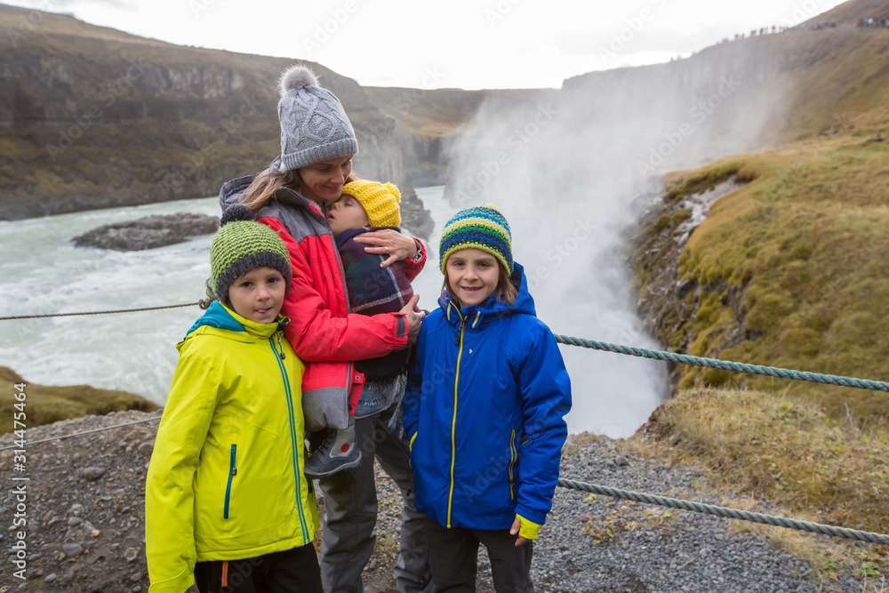 Mother with children, enjoying the big majestic Gullfoss waterfall in mountains in Iceland