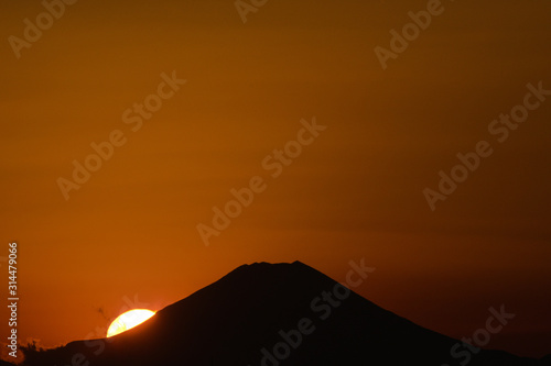 mount fuji in japan silouetted against an orange sunset sky