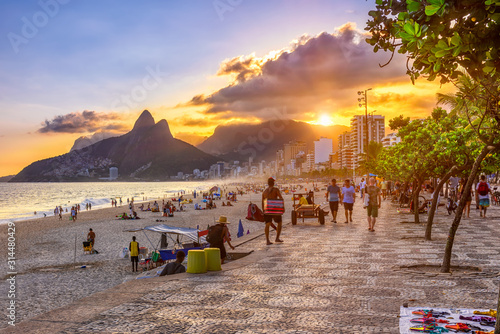 Sunset view of Ipanema beach with mosaic of sidewalk, Leblon beach and the Mountain Dois Irmao in Rio de Janeiro. Brazil