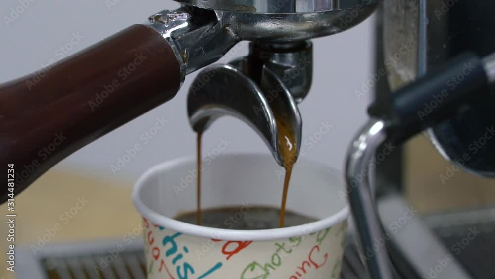 Close up view of black coffee pouring into paper cup slow motion. Coffee preparation process concept. Close up view of black coffee pouring into paper cup slow motion. Coffee preparation process concept.