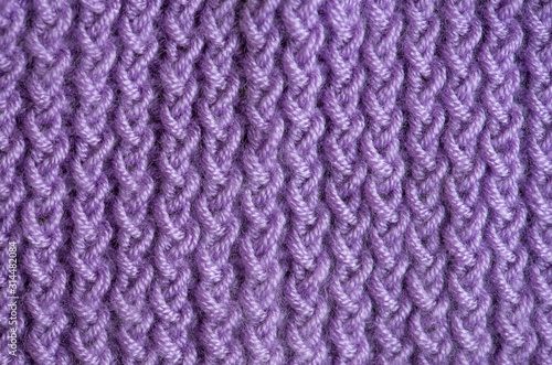 Close-up, violet handmade knitting fabric texture background.