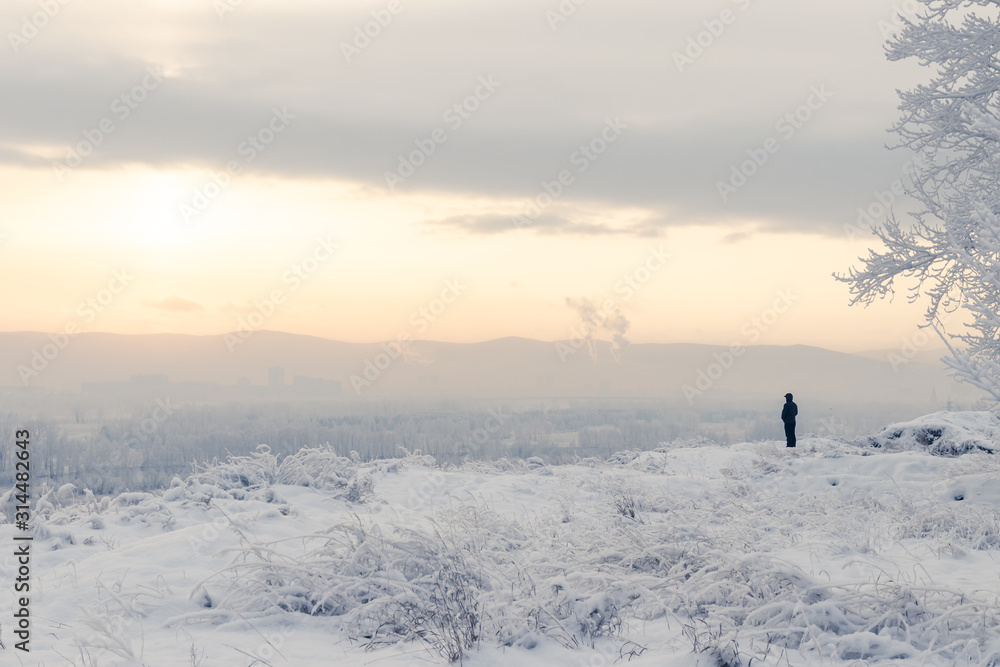 Winter landscape - A man stands on the edge of a cliff and looks