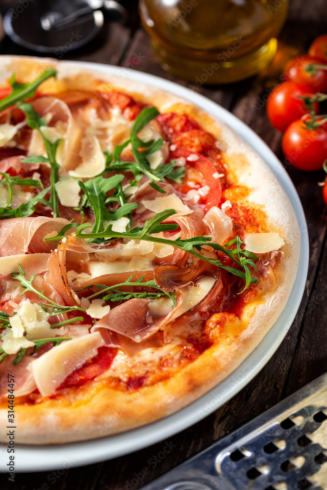 Close up of tasty pizza with rocket plant leaves covering the toppings Close up of tasty pizza with rocket plant leaves covering the toppings