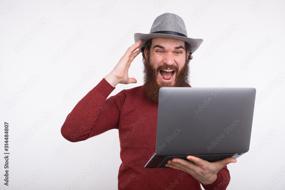 Photo of amazed man looking at his laptop and screaming Photo of amazed man looking at his laptop and screaming