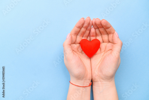 Heart in hands on a blue background. The concept of Valentine s Day and Women s Day. Top view  place for text. a life