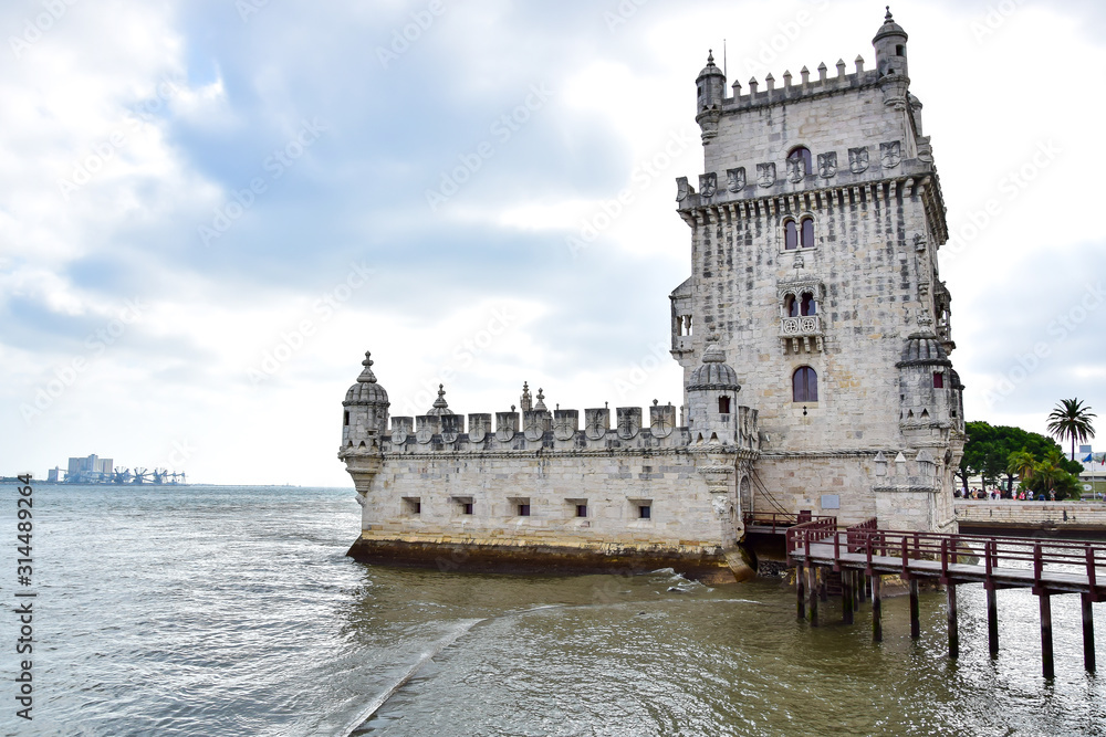 Lisbon, Portugal - Fort Tower of Belém (Torre de Belem), served as a small defensive fortress, a powder warehouse, prison and customs, against the background of clouds, on the Tagus River.