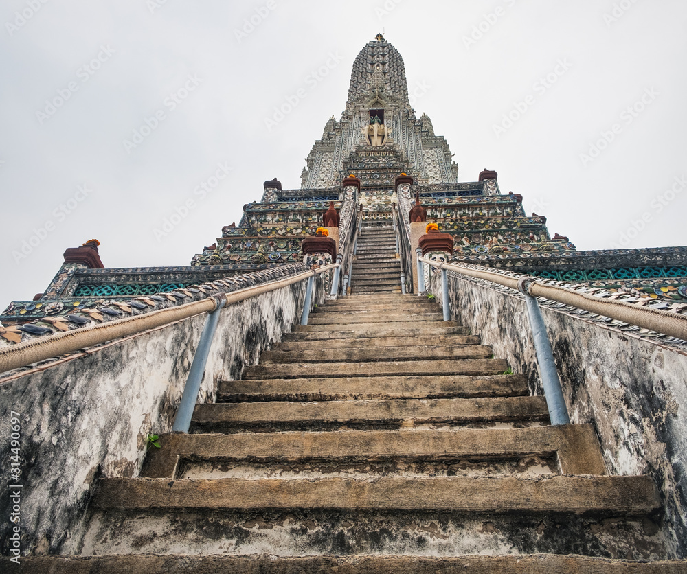 Stairs to the top of Stupa-like pagoda encrusted with coloured faience in Temple of Dawn, Wat Arun, Bangkok, Thailand.