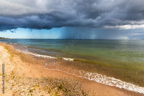 Sandy beach in Harilaid peninsula in Vilsandi national park, Saaremaa island, Estonia with the dark blue  rain and thunder front background photo