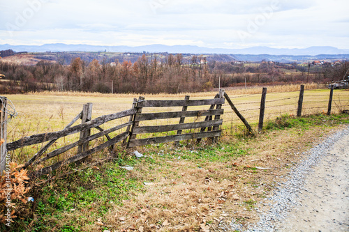 Fototapeta Naklejka Na Ścianę i Meble -  Wooden fence at farmland, autumn season, rural landscape