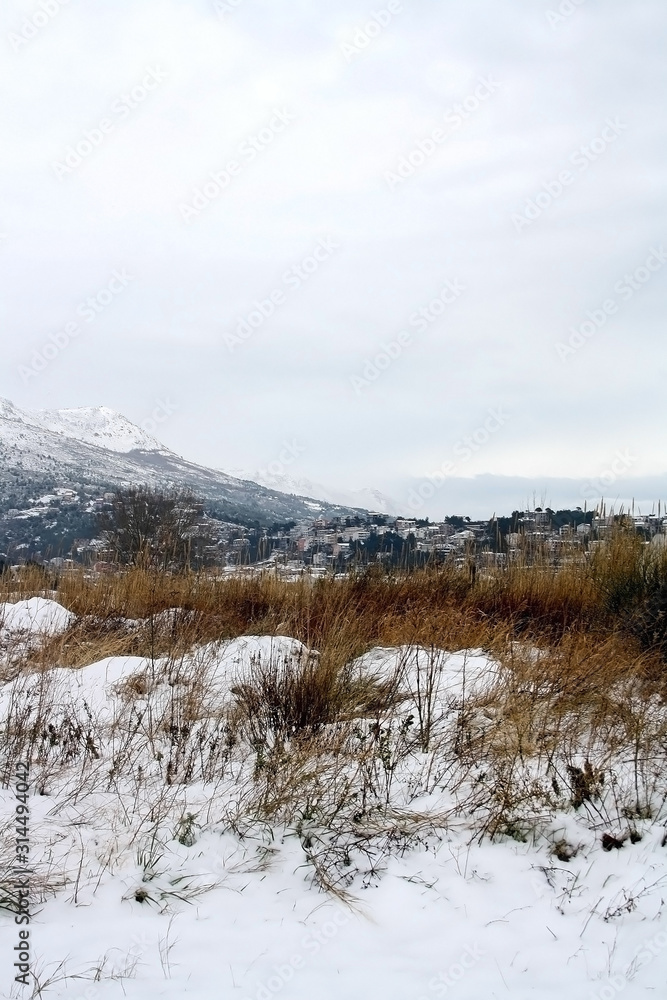 Meadow covered in snow, mountain in the background. Selective focus. Meadow covered in snow, mountain in the background. Selective focus.