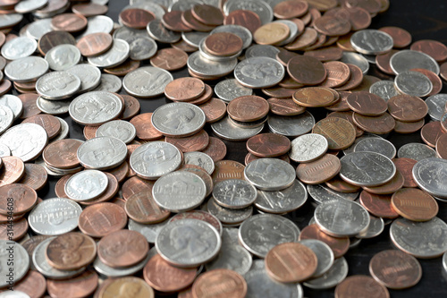 A pile of American cents on an old black wooden surface close-up. Money background