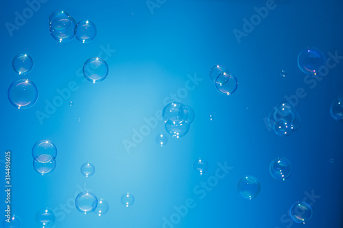 Soap bubbles in air with float on blue background