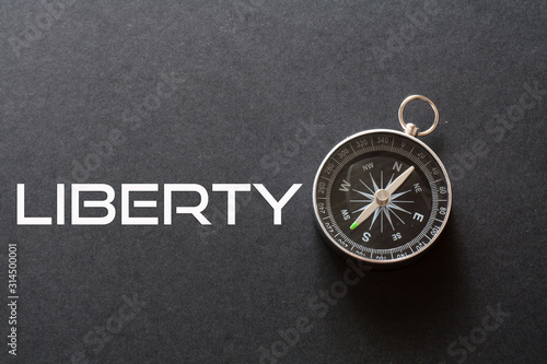 Liberty word written on black background with compass © Lemau Studio