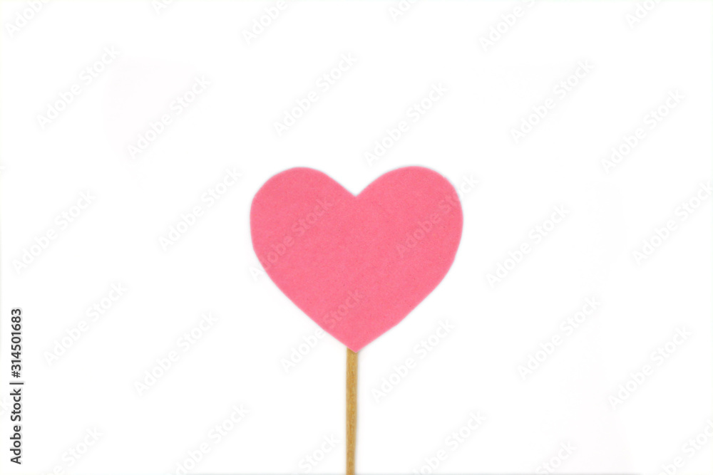Оne pink felt heart on a stick on a white isolated background. Stock photo for the day of St. Valentine with empty space for your text. For web, print, postcards and wallpaper.