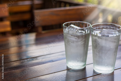 2 Glass with ice and cold water on wood table.