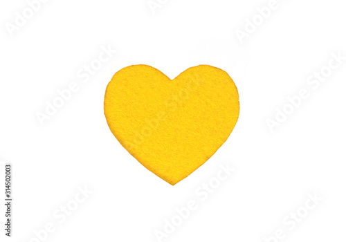 Оne felt yellow heart on a white isolated background. Stock photo for the day of St. Valentine with empty space for your text. For web, print, postcards and wallpaper.