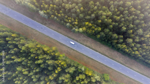 Conceptual aerail top down image of the highway cutting through the natural woodland habitat photo