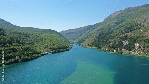 Aerial view of Trebisnjica river mountainous valley, Lastva village, Bosnia and Herzegovina. Turquoise water, green hills.