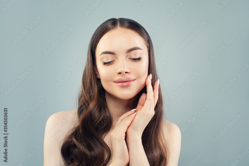 Beautiful woman touching her skin her hand on blue background