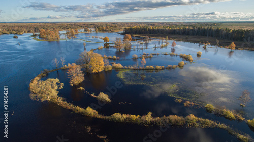 Aerail view over flooded rive plain and river bends marked with the autumn colored plants and trees in Soomaa national park, Estonia