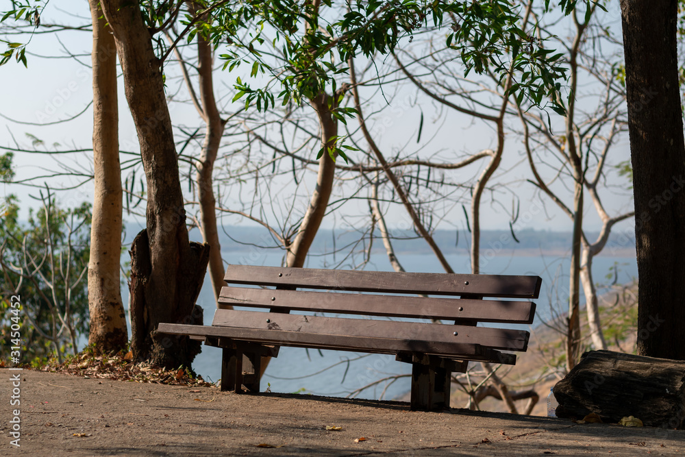 Wooden chairs in the park with morning sun, warm atmosphere Wooden chairs in the park with morning sun, warm atmosphere