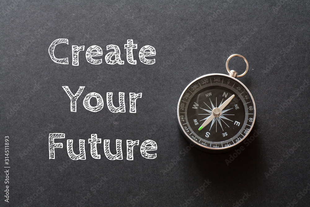 Written Create your future words on black background with compass Written Create your future words on black background with compass